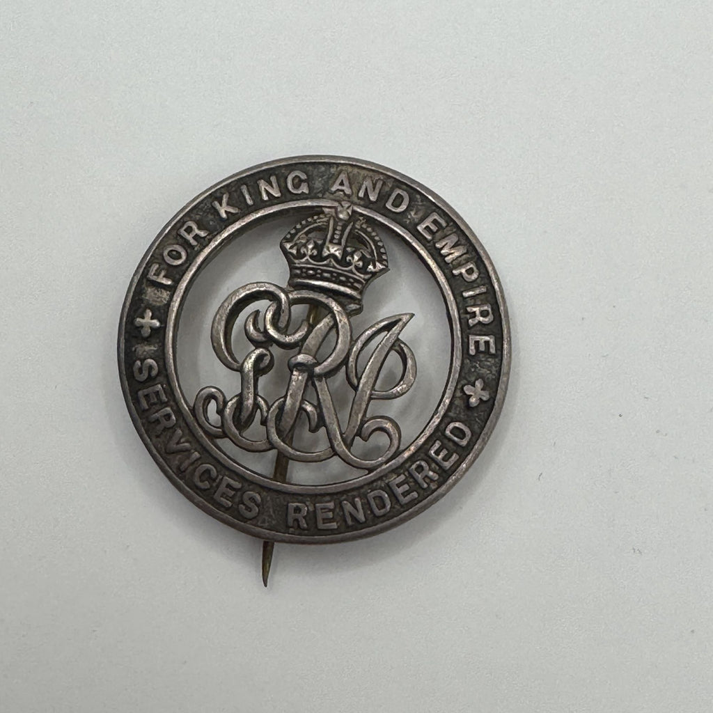 Silver badge with text 'For King and Empire' on a light gray background